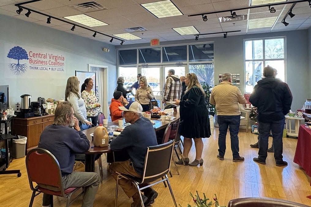 CVABC open house in the Forest office, with the coalition wall logo and members gathered around a table